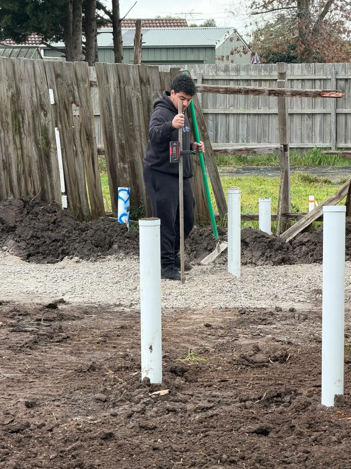 Plumber setting out plumbing risers that will come up through the slab